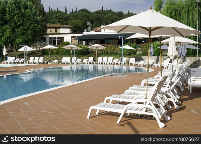 Pool and white sun loungers. Rounded shapes pool