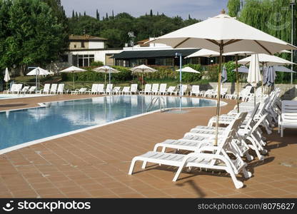 Pool and white sun loungers. Rounded shapes pool