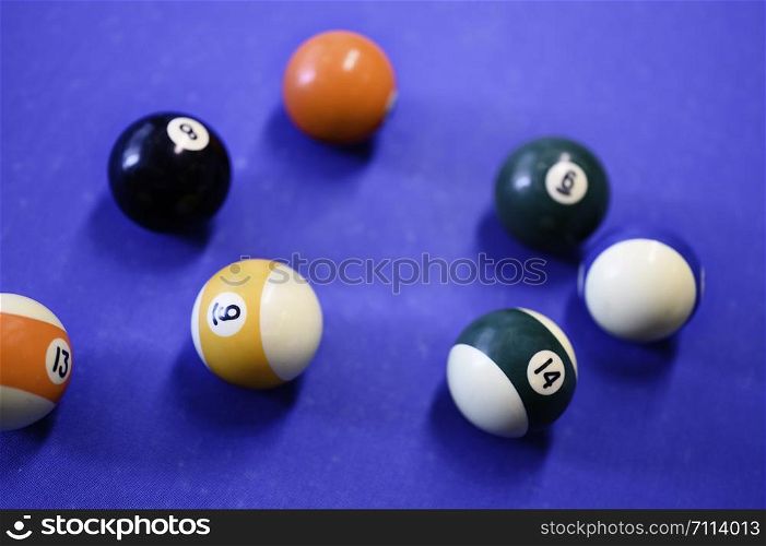 Pool billiard balls on blue table.
