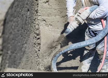 Pool Construction Worker Shooting Concrete, Shotcrete or Gunite Through Hose