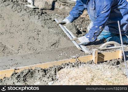 Pool Construction Worker Working With A Smoother Rod On Wet Concrete