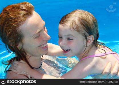 Pool mother and daughter playing together swimming lesson learning