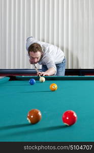 Pool player taking a shot at the yellow ball