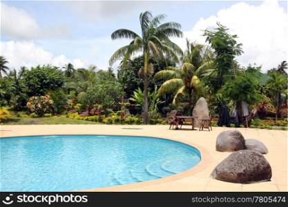 Pool with blue water and palm trees in hotel, Samoa
