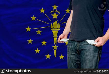 poor man showing empty pockets in front of american state of indiana flag