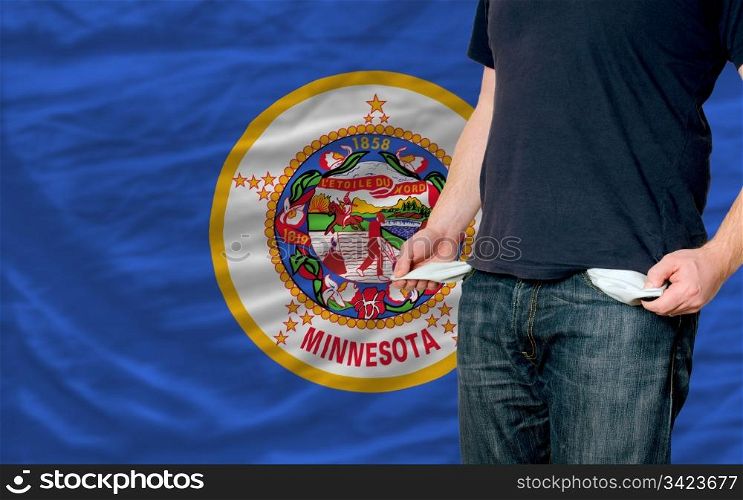 poor man showing empty pockets in front of american state of minnesota flag