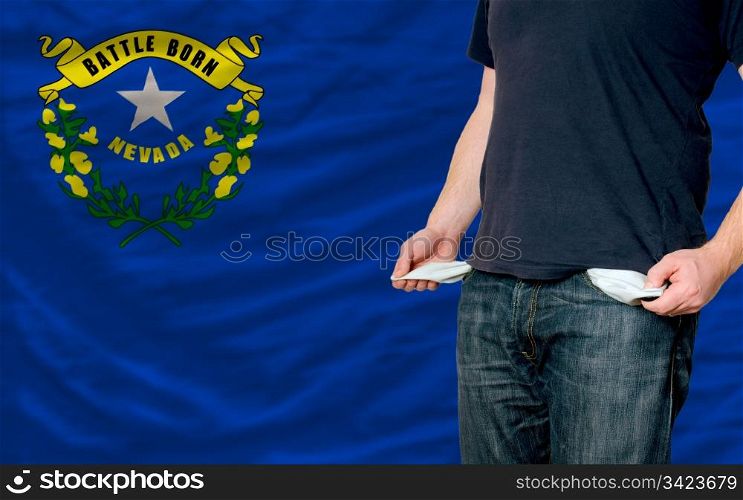 poor man showing empty pockets in front of american state of nevada flag