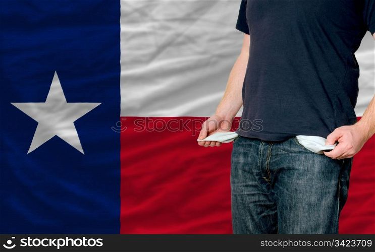 poor man showing empty pockets in front of american state of texas flag