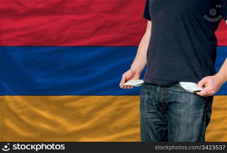 poor man showing empty pockets in front of armenia flag