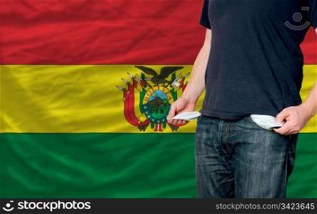 poor man showing empty pockets in front of bolivia flag
