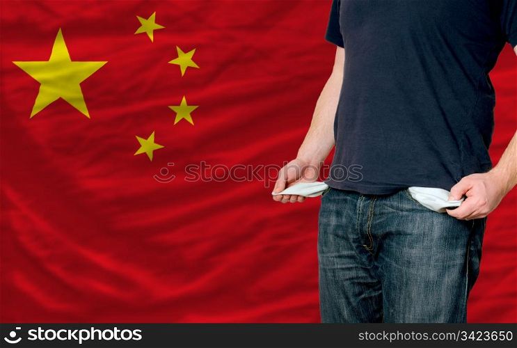 poor man showing empty pockets in front of china flag
