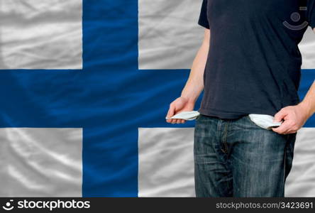 poor man showing empty pockets in front of finland flag