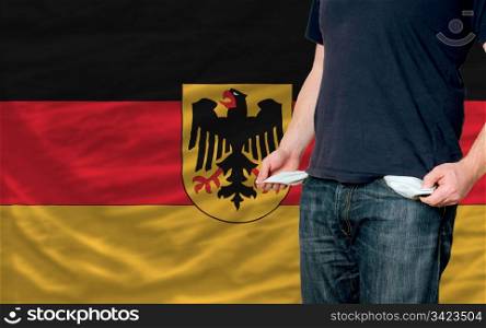 poor man showing empty pockets in front of germany flag