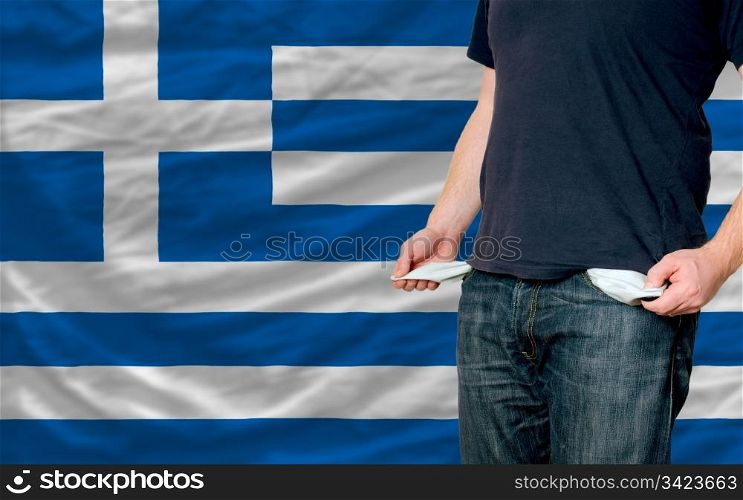 poor man showing empty pockets in front of greece flag