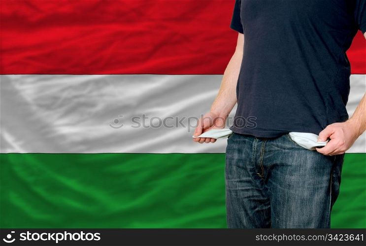 poor man showing empty pockets in front of hungary flag