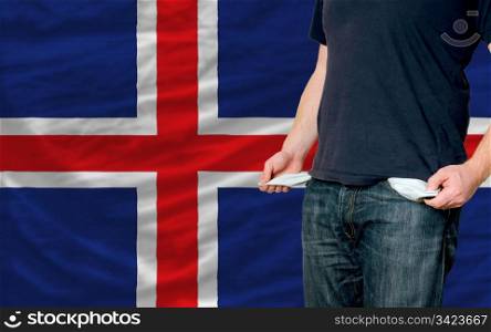 poor man showing empty pockets in front of iceland flag