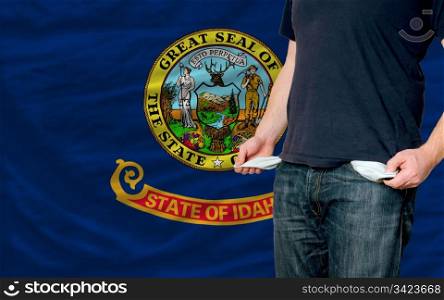 poor man showing empty pockets in front of idaho flag