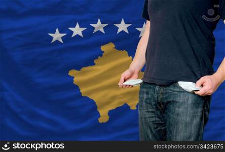 poor man showing empty pockets in front of kosovo flag