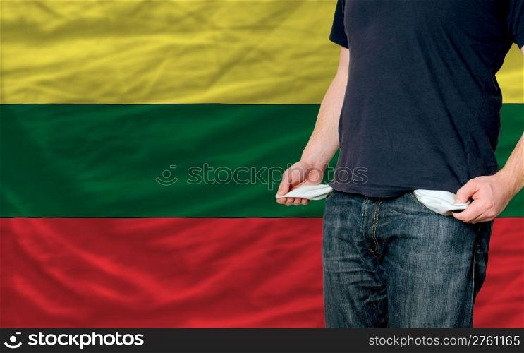 poor man showing empty pockets in front of lithuania flag