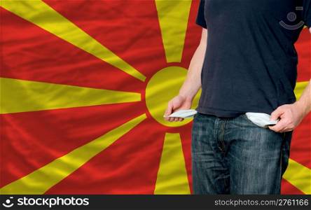 poor man showing empty pockets in front of macedonia flag