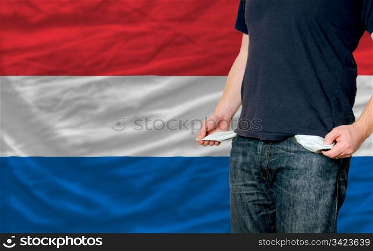 poor man showing empty pockets in front of netherlands flag