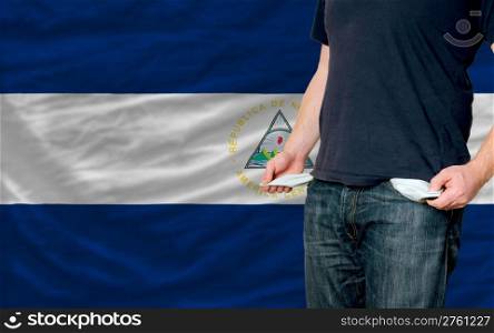 poor man showing empty pockets in front of nicaragua flag