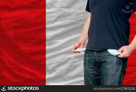 poor man showing empty pockets in front of peru flag
