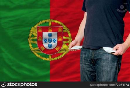 poor man showing empty pockets in front of portugal flag