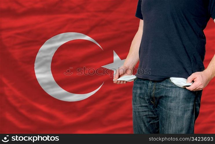 poor man showing empty pockets in front of turkey flag