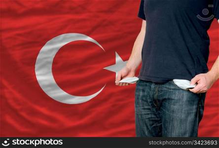 poor man showing empty pockets in front of turkey flag