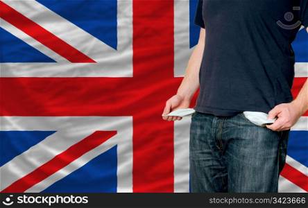 poor man showing empty pockets in front of uk flag