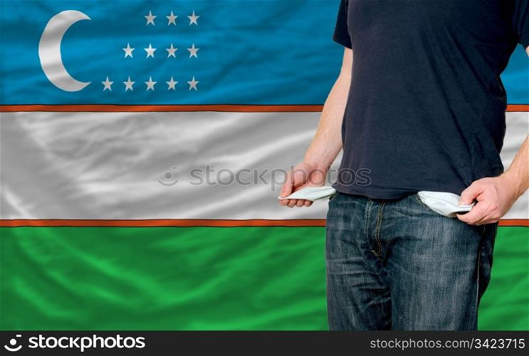 poor man showing empty pockets in front of uzbekistan flag