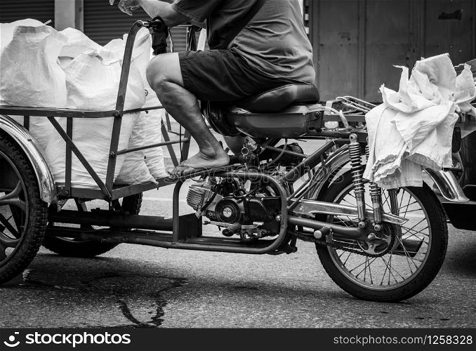 Poor senior man driving a motorbike, sending ice bag to a restaurant. Elderly people work after retirement. Retirement money crisis concept. Welfare government and social security. Aging society.