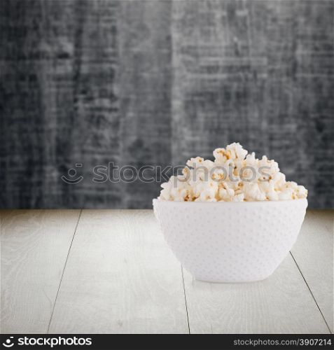 Pop corn bowl on wood table background.