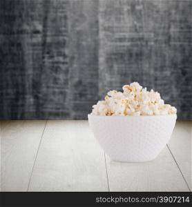 Pop corn bowl on wood table background.