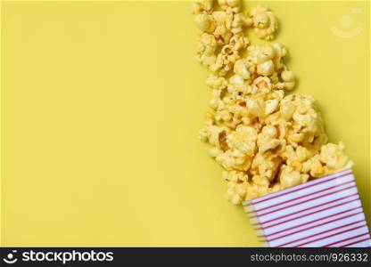 Popcorn cup box on yellow top view / Sweet butter popcorn background