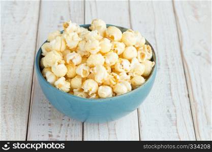 Popcorn in blue cup on white wood table