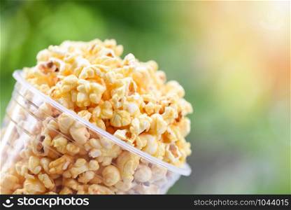 Popcorn in cup and nature green and sunlight backgroubd / Sweet butter popcorn salt