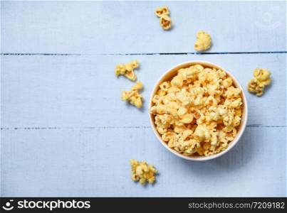 Popcorn in cup bowl and blue wooden backgroubd top view / Sweet butter popcorn salt