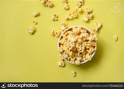 Popcorn in cup bowl and yellow backgroubd top view / Sweet butter popcorn salt