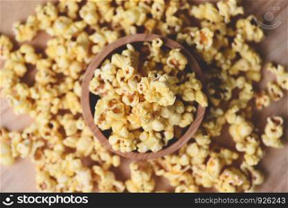 Popcorn in wooden cup bowl and wood backgroubd top view / Sweet butter popcorn salt