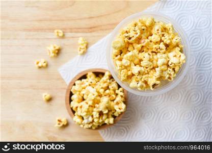 Popcorn in wooden cup bowl and wood backgroubd top view / Sweet butter popcorn salt