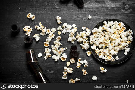 Popcorn with the movie films . On the black wooden table.. Popcorn with the movie films .