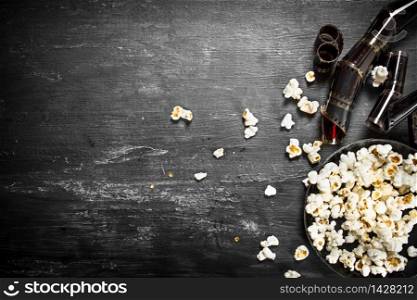 Popcorn with the movie films . On the black wooden table.. Popcorn with the movie films .