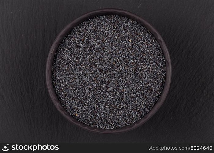 poppy seeds in a stone bowl on a dark background