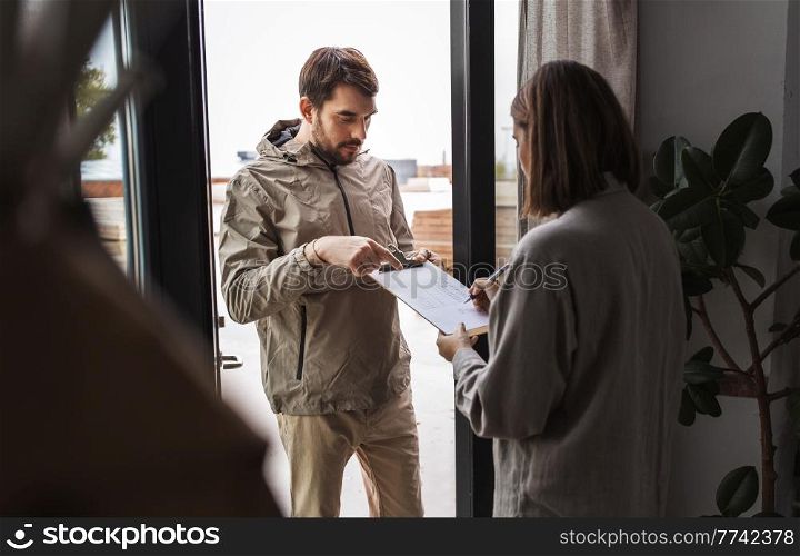 population census, polling and people concept - male social worker asking woman sign papers on clipboard at home. man asking woman to sign papers on clipboard