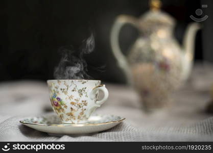 Porcelain tea pot and cup of hot tea on the table, antique traditional crockery set, high tea English afternoon tea cozy stylish interior. Porcelain tea pot and cup of hot tea on the table, antique traditional crockery set, high tea English afternoon tea