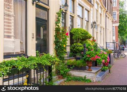 Porch of a house decorated with flowers and green plants in a typical Amsterdam street, Holland, Netherlands