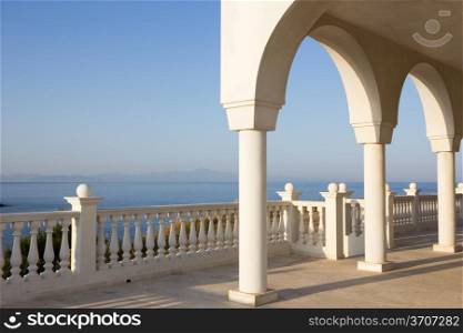 Porch with arches and columns of orthodox church Profitis Ilias in Keratea, near Lavrio, in East Attika, Greece, overlooking the Aegean Sea.