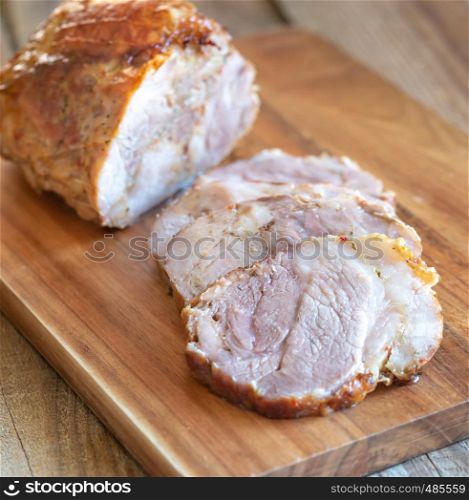 Porchetta - Italian roasted pork on the wooden board